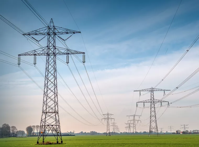 Large powerlines in a rural farm setting. Exponent helps stakeholders explore safer, more efficient and alternative energy solutions.