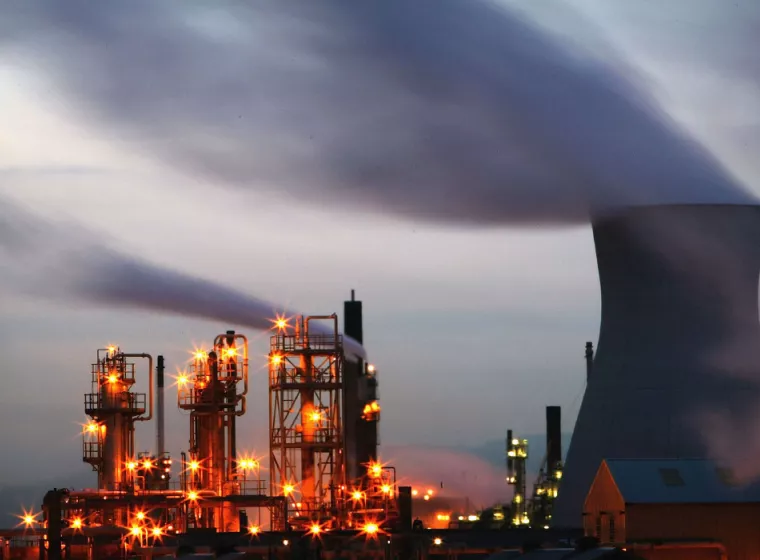 An energy facility of multiple reactors with smoke billowing from the top 