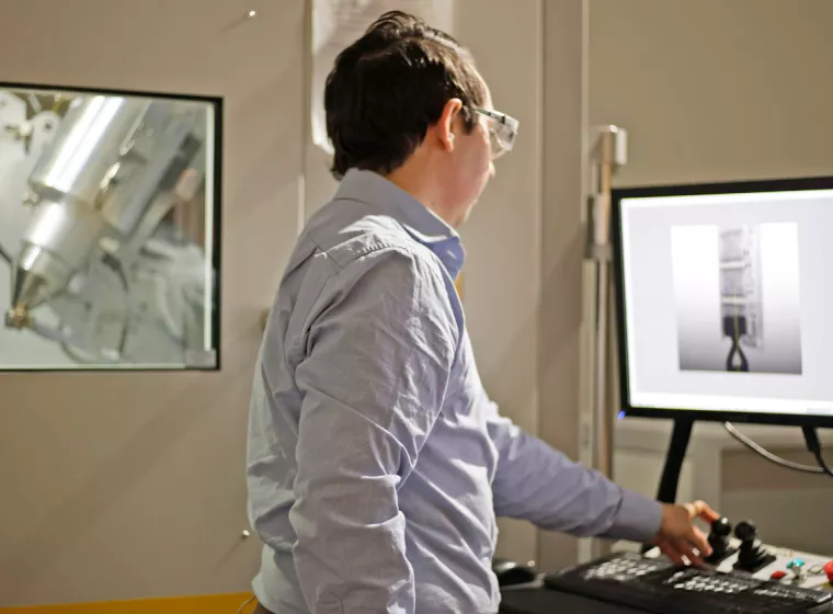 A scientist analyzes images of batteries on two computer screens. Exponent engineers help improve the safety and performance of batteries. 