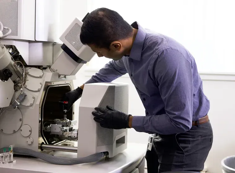 Exponent scientist operating equipment in a lab