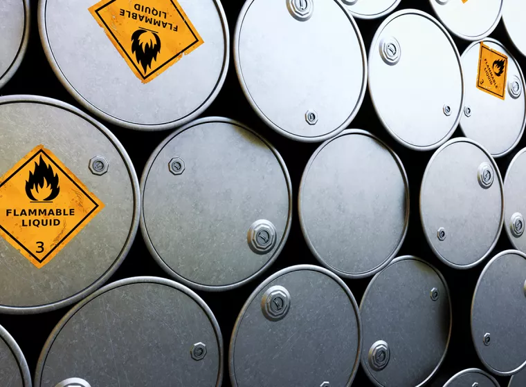 Stacks of steel barrels labeled with flammable liquid warning signs. Exponent helps improve safety of hazardous chemicals.