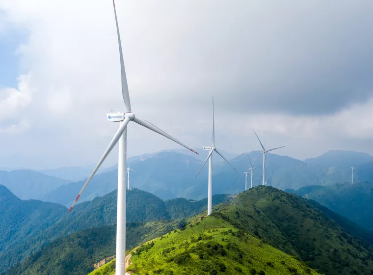 Wind turbines on a mountain range. Exponent's Environment & Sustainability expertise helps you make informed decisions.