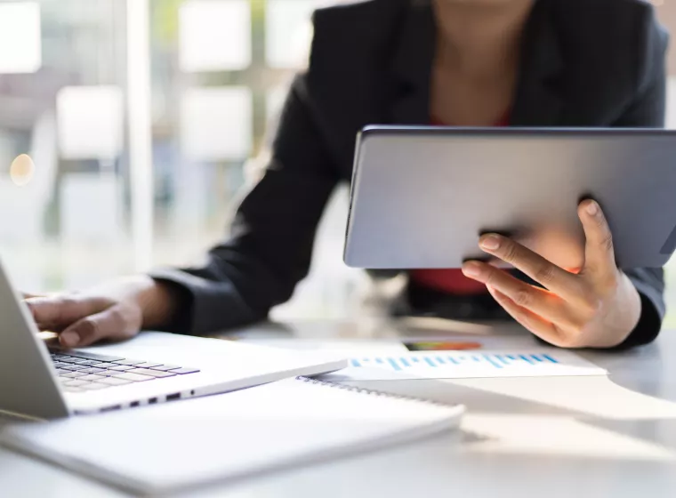 Expert refers to a laptop while taking notes. Exponent provides expert data science support for all industries.