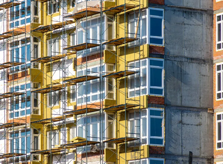 construction work at height during facade insulation from scaffolding or staging, selective focus