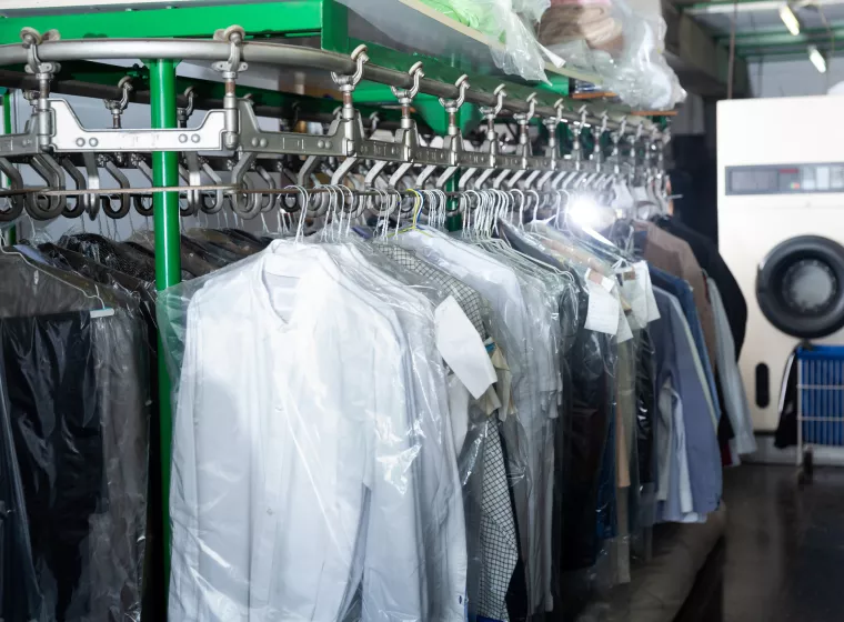 Clothes in plastic bags hanging at dry-cleaning