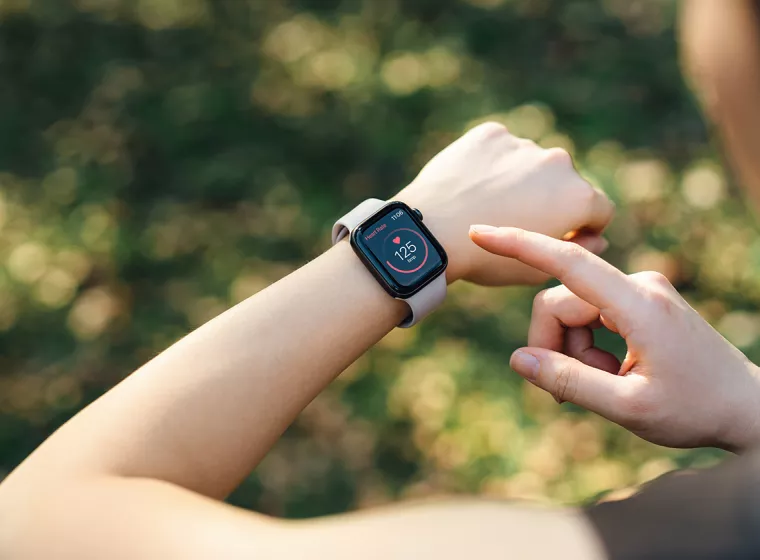 A runner checks their smartwatch. Exponent helps manufacturers develop safer and more innovative health monitoring and wearable devices.