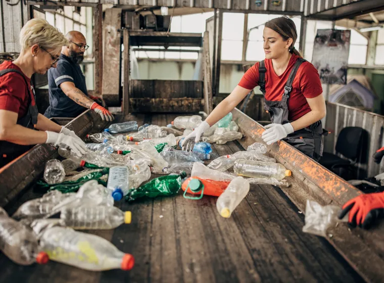 Group of workers at the recycling centre sorting plastic waste ad preparing for recycling