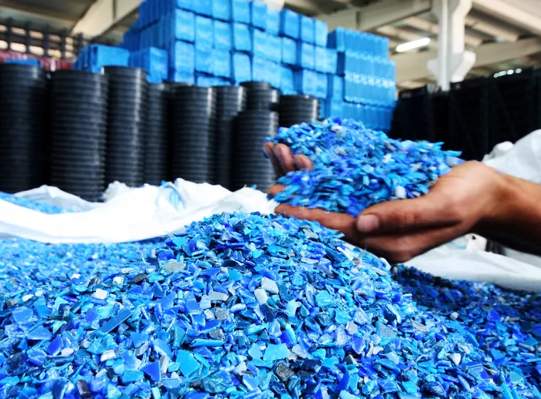 A worker sorts polymers in manufacturing assembly. Exponent polymer science and materials chemistry consulting.