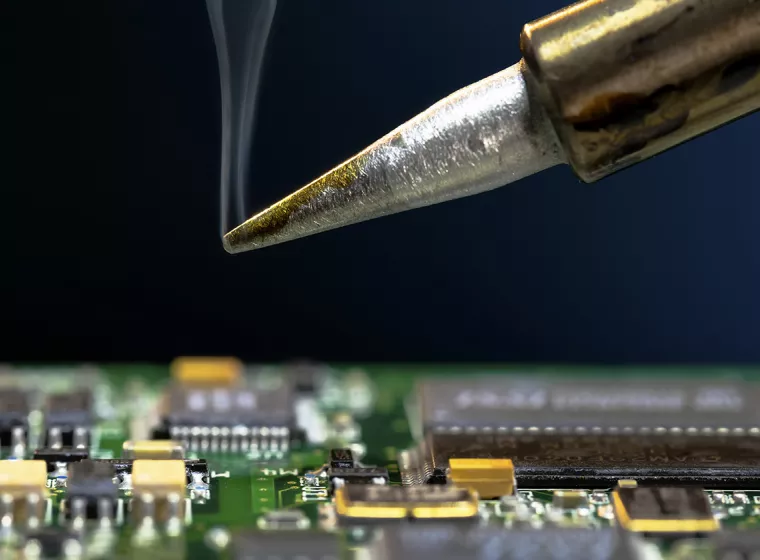 An expert analyzes a circuit board. Exponent engineers provide expert analysis of discrete components & printed circuit boards