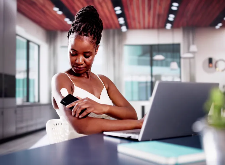 Woman Testing Glucose Level With Continuous Glucose Monitor On Mobile Phone