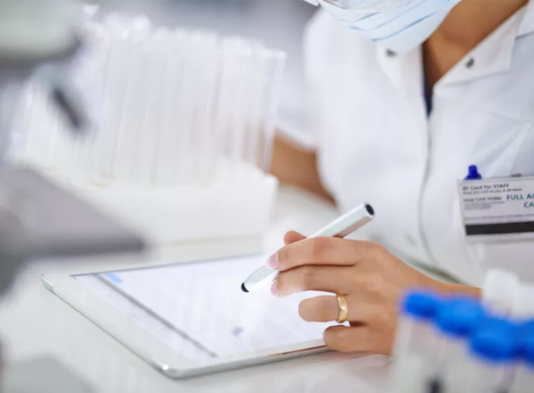 Medical lab coat and employee badge. Exponent assists with pharmaceutical research for medical innovators.