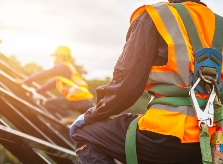 Workers wearing bright construction safety gear. Exponent helps clients identify workplace hazards and mitigate risk of injury.