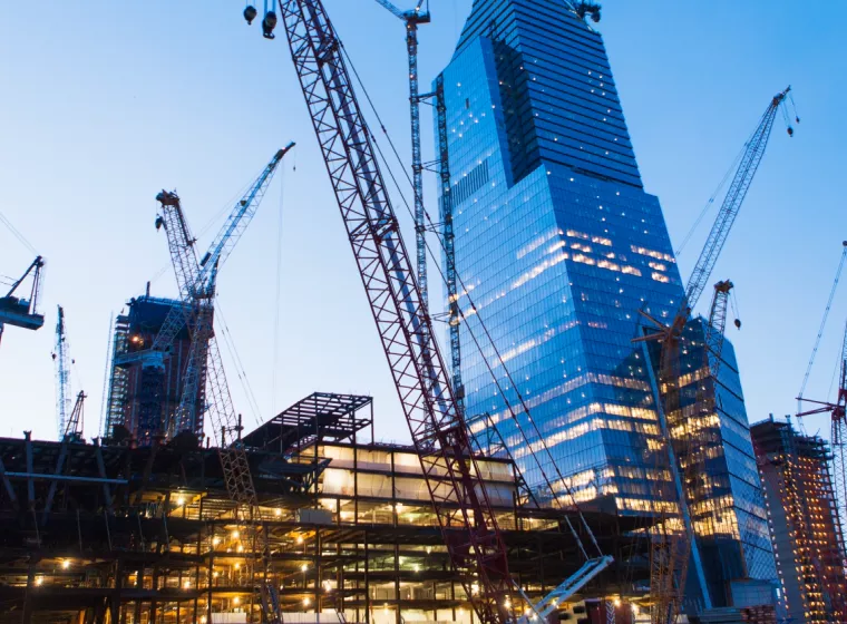 Skyscrapers surrounded by industrial cranes. Exponent technical support for construction claims.