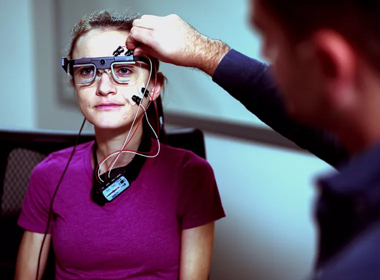 Exponent scientists attach bio sensors to a young person in a user experience lab to monitor movement. 