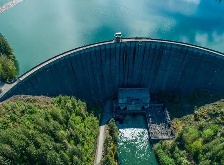 Aerial view of a large dam on a lake. Exponent engineers and scientists help stakeholders manage and improve valuable water resources. 