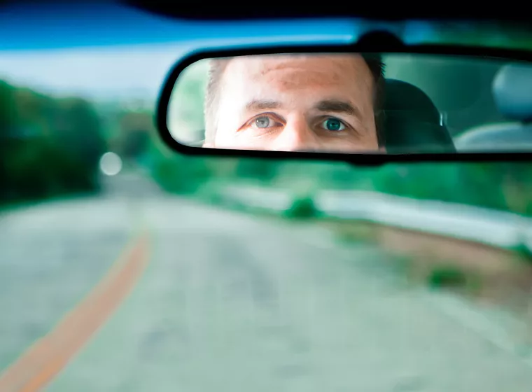 Man driving looking at rearview mirror