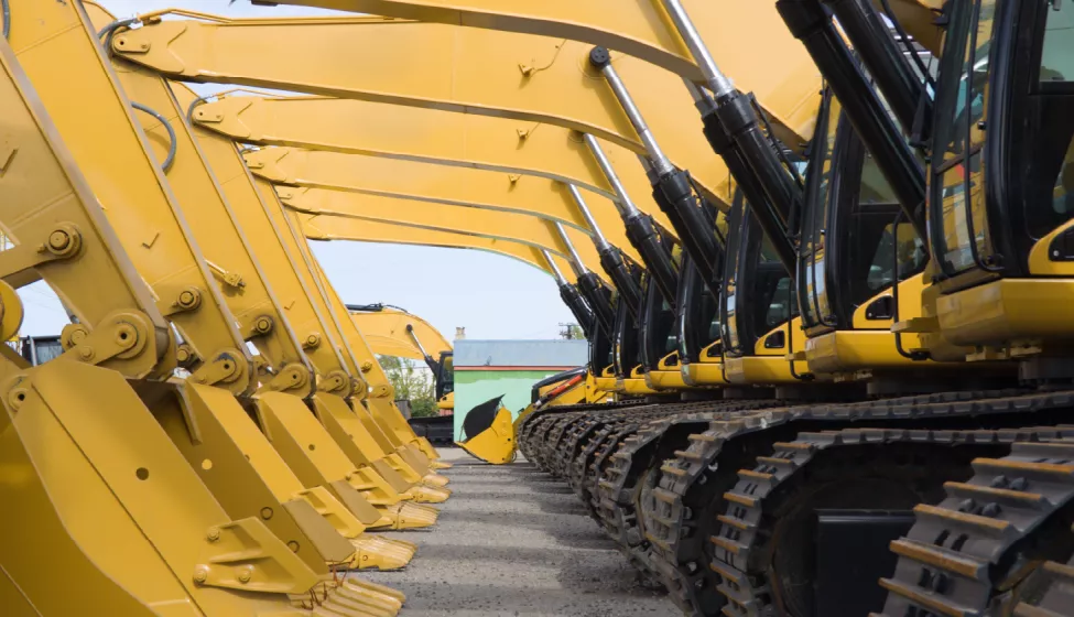 Parked bulldozers lined up side by side