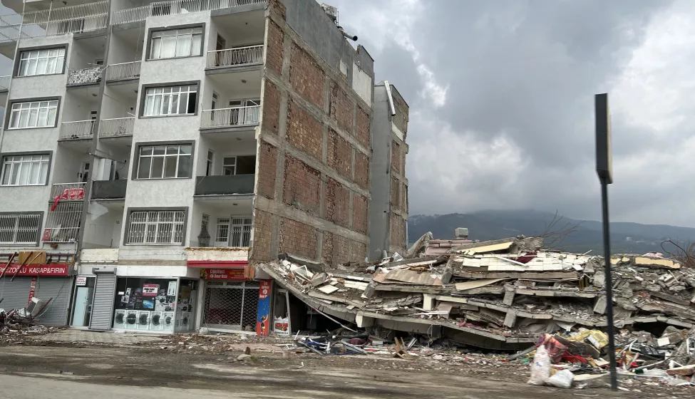 A completely collapsed building on the right on of one still standing following the Turkey earthquake