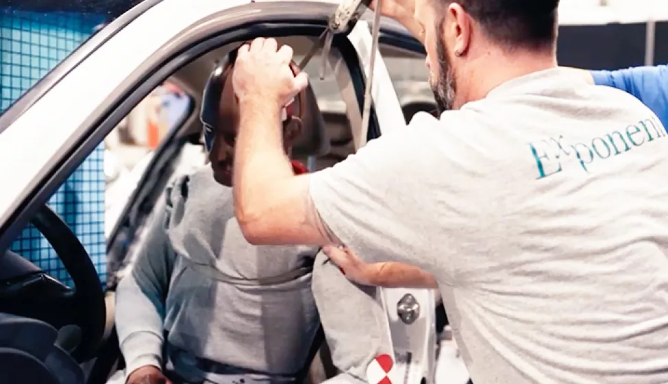 Man with dummy in car at lab