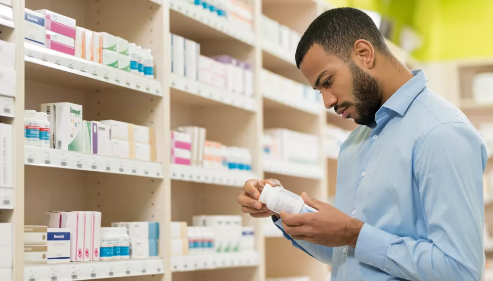 Man Choosing Supplement In Drugstore