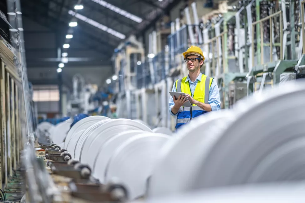 Manufacturing Engineer holding a tablet while working at plastic bag factory