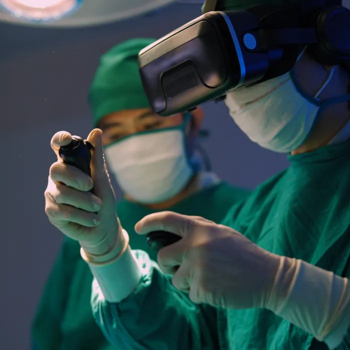Professional surgeons in uniform and VR headset performing operation