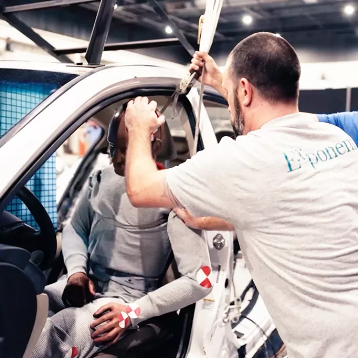 Man with dummy in car at lab