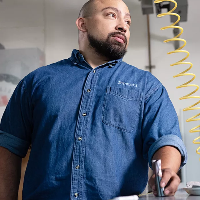 Employee in lab holding metal pipe