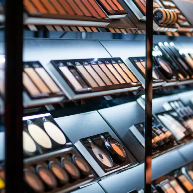 A display shelf in a cosmetic store holding various shades of pressed powders