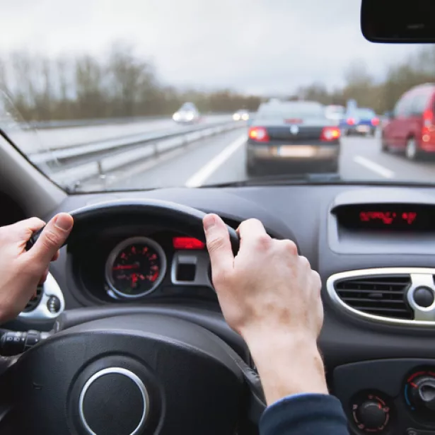 A driver navigating their car on a busy highway. Exponent's vehicle engineers and researchers support innovative driving technologies.