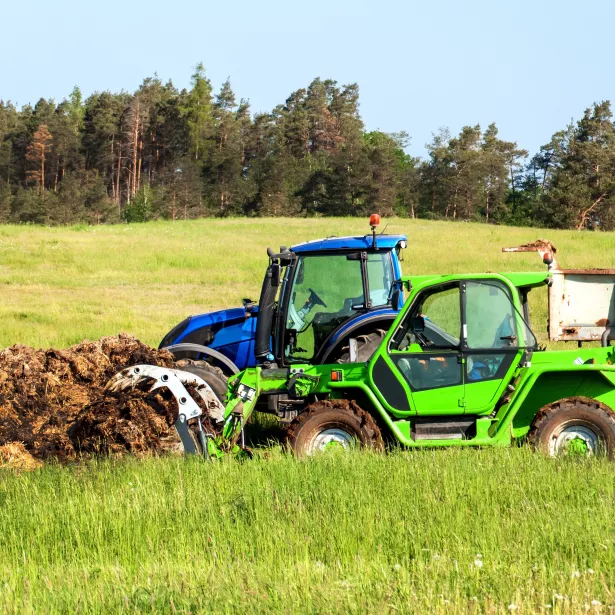 Loading Manure onto a tractor in a field