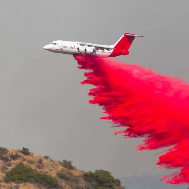 Pink fire retardant drops from a plane.