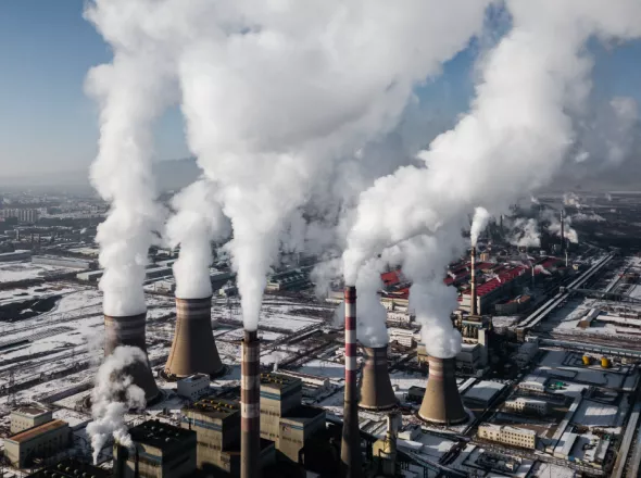 Industrial smoke stacks emit steam in winter 