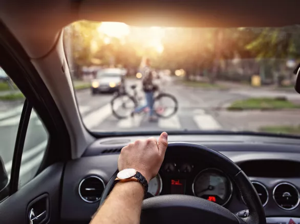 POV of a driver with a pedestrian crossing a crosswalk in front of them
