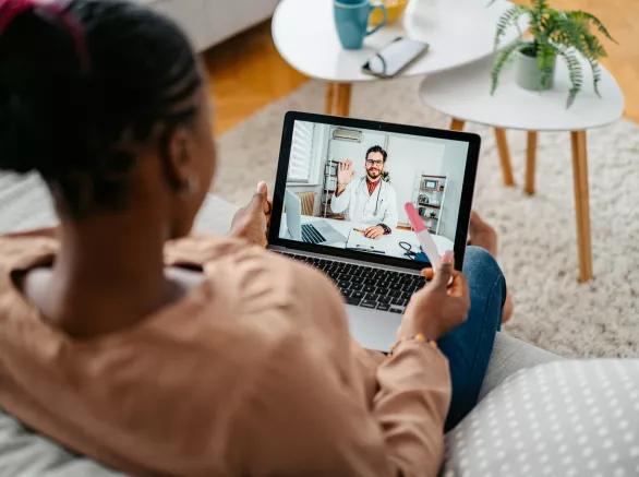Young Pregnant Woman Having A Doctor's Appointment On A Laptop