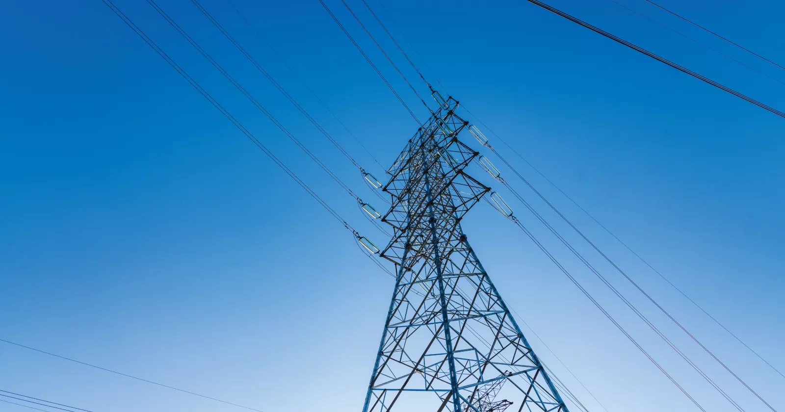 A view of electric lines from the point of view at the base of the tower