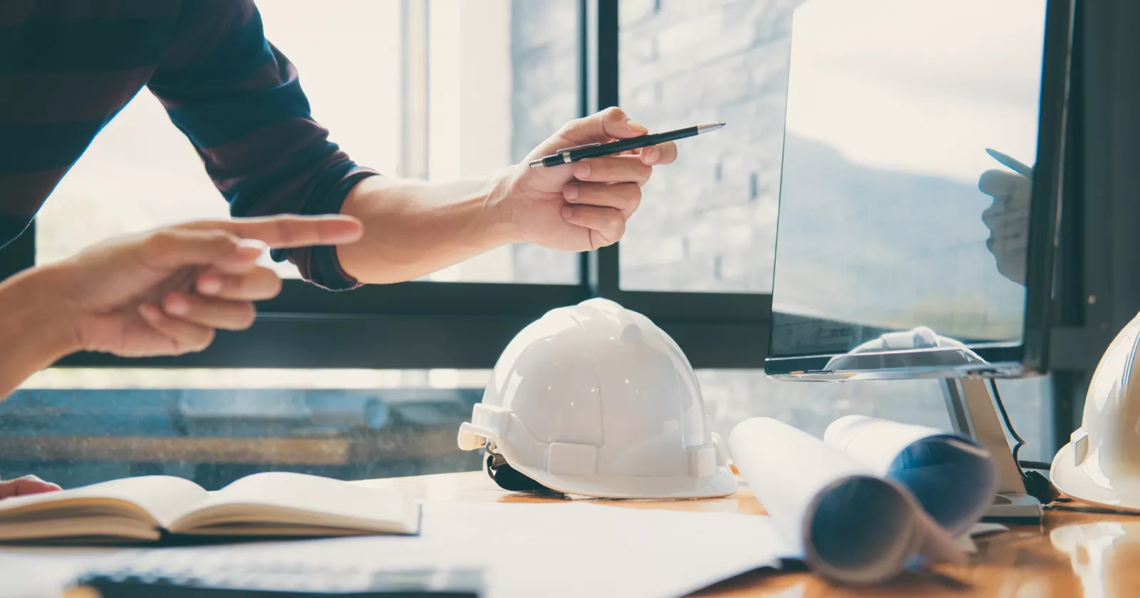 Construction consultant in an office meeting on cell phone, Exponent project management and schedule audits.