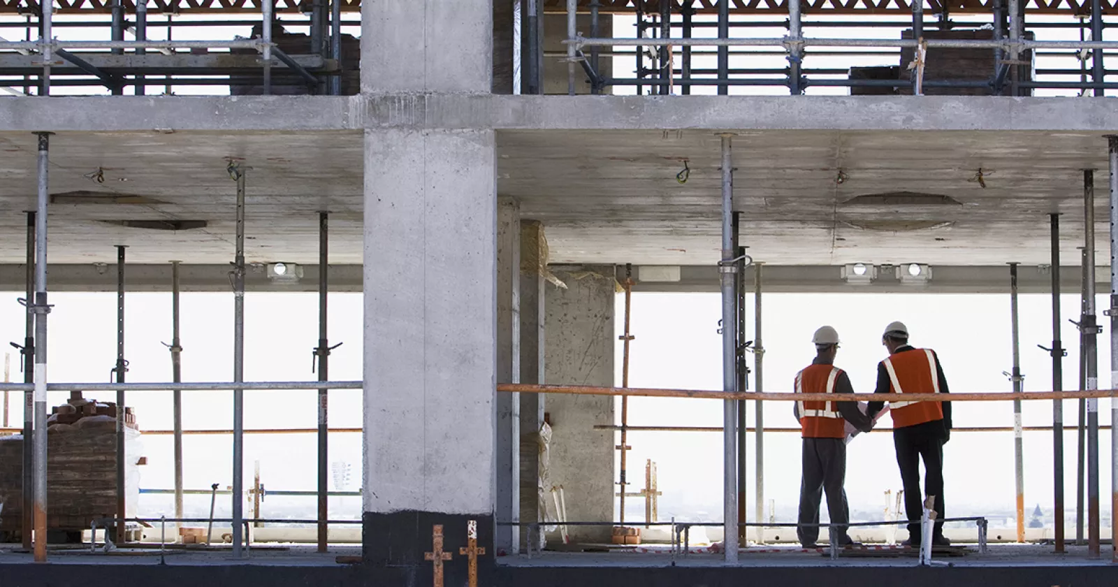 Two professionals on a buidling construction site. Exponent engineers consult on construction design defects.