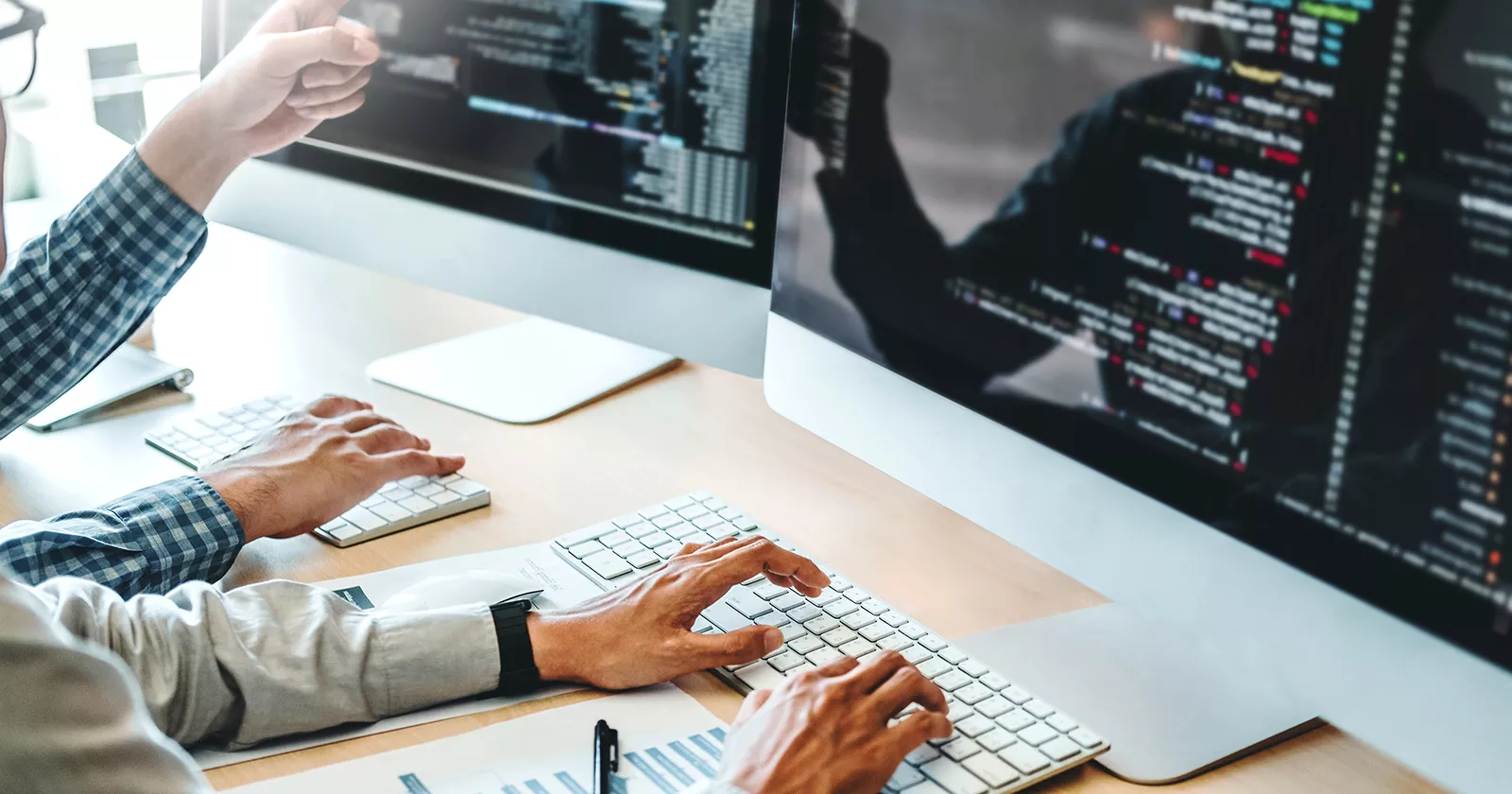 Hands typing on a keyboard while analyzing data on a computer screen. Exponent helps enhance the platforms and systems that drive business.