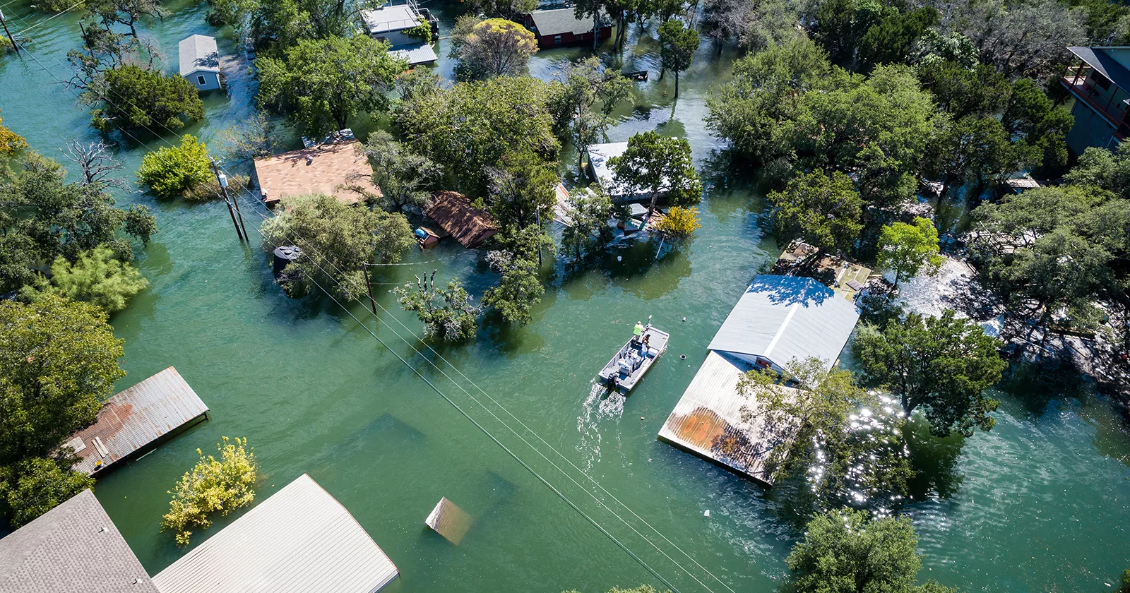 Flat bottom boat navigates through flooded neighborhoods. Exponent engineers respond to storms and natural disasters.