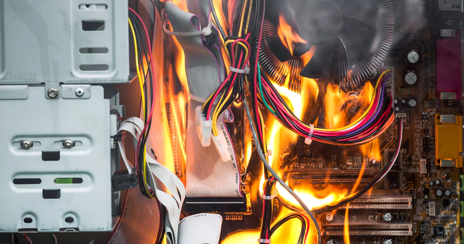 A computer tower and circuit boards are engulfed in flames. Exponent electrical engineers construct detailed accident reconstructions.