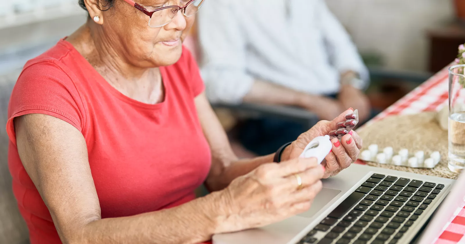 Patient looking over their prescriptions while sitting in front of a laptop