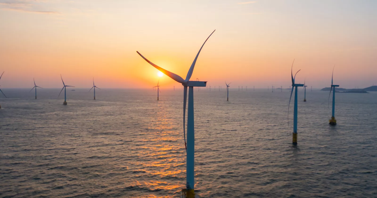 Close-up of wind turbines at sea at sunrise 