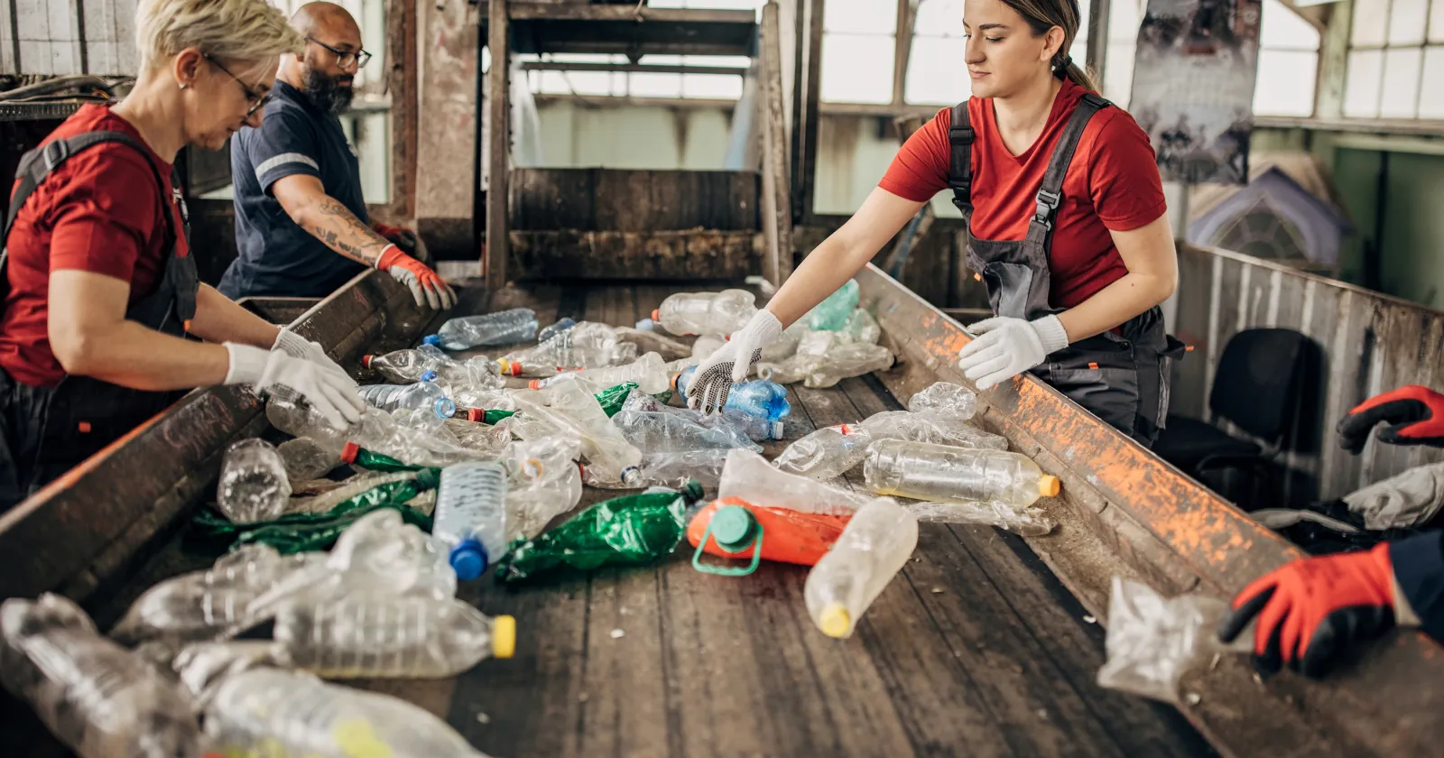 Group of workers at the recycling centre sorting plastic waste ad preparing for recycling