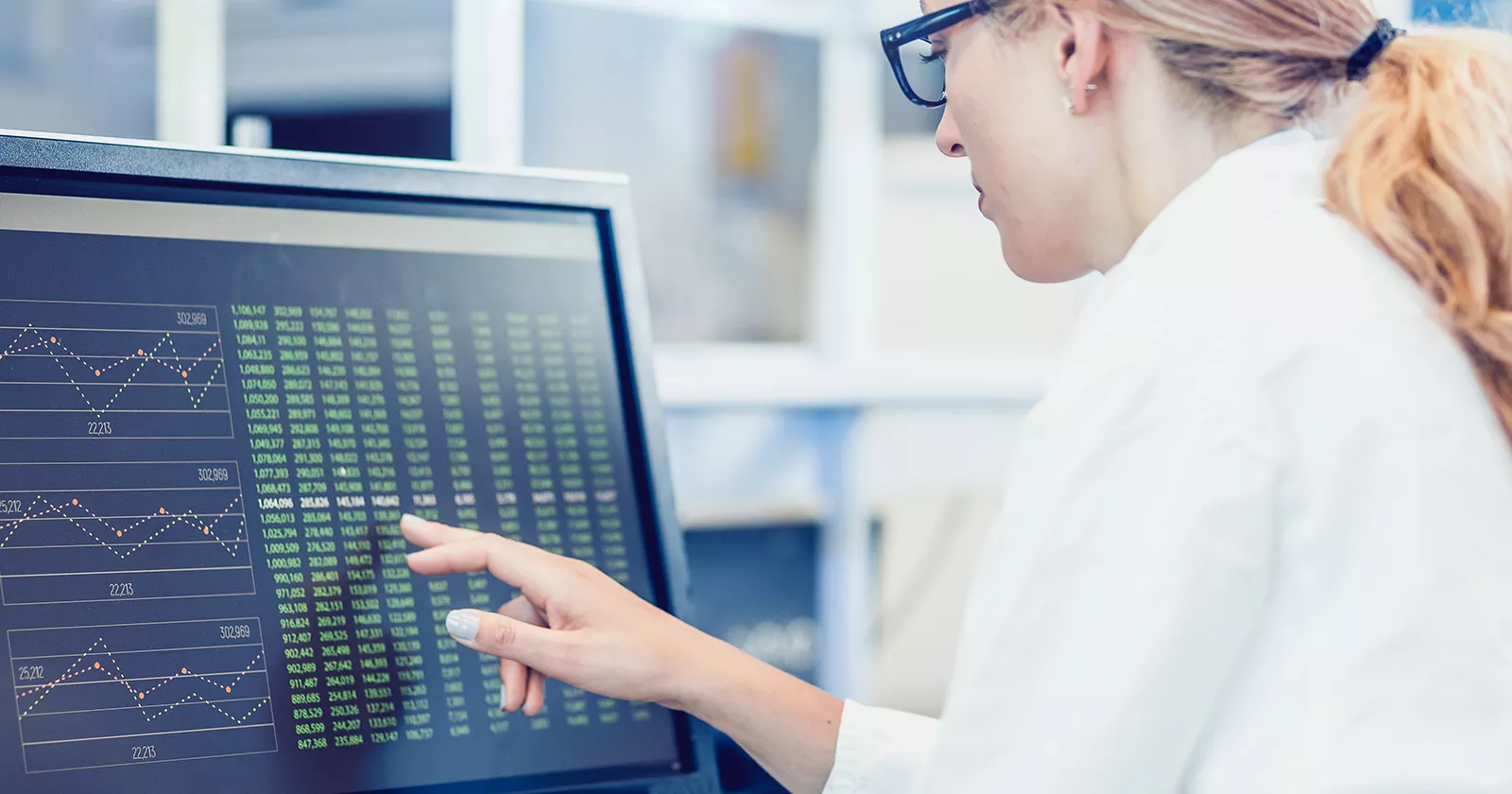 Researcher analyzes a list of numbers on a computer screen. Exponent data scientists provide important data tests and analysis.