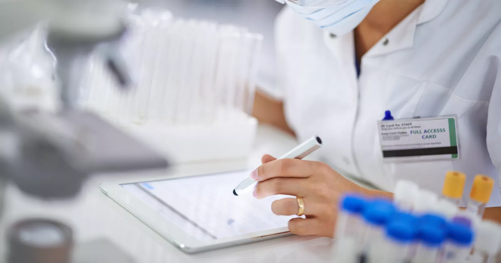 Medical lab coat and employee badge. Exponent assists with pharmaceutical research for medical innovators.