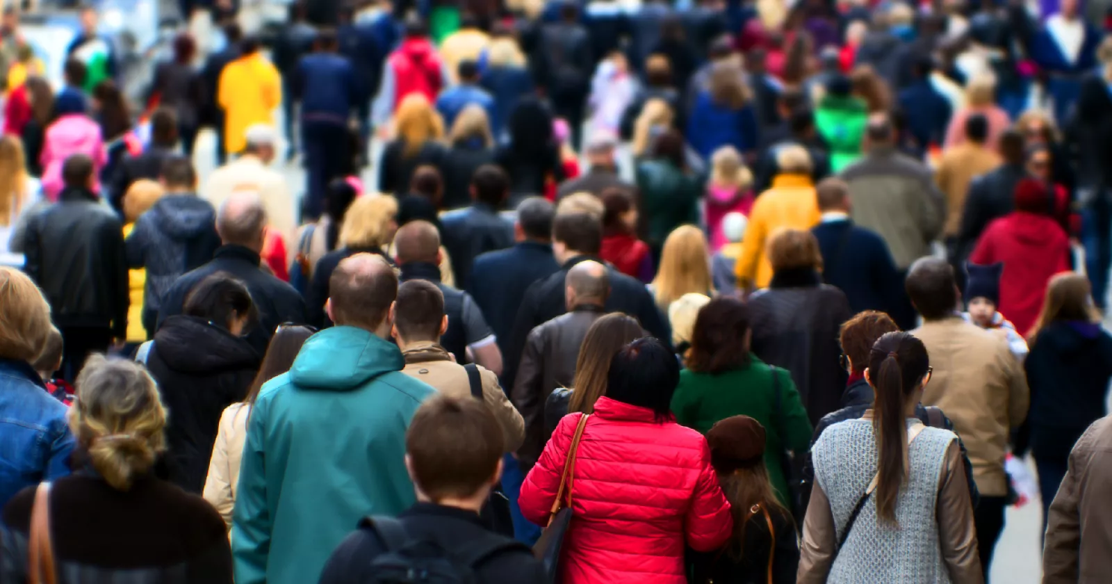 Crowd of people wearing coats and walking on sidewalk. Exponent conducts epidemiological and  biostatistical research.