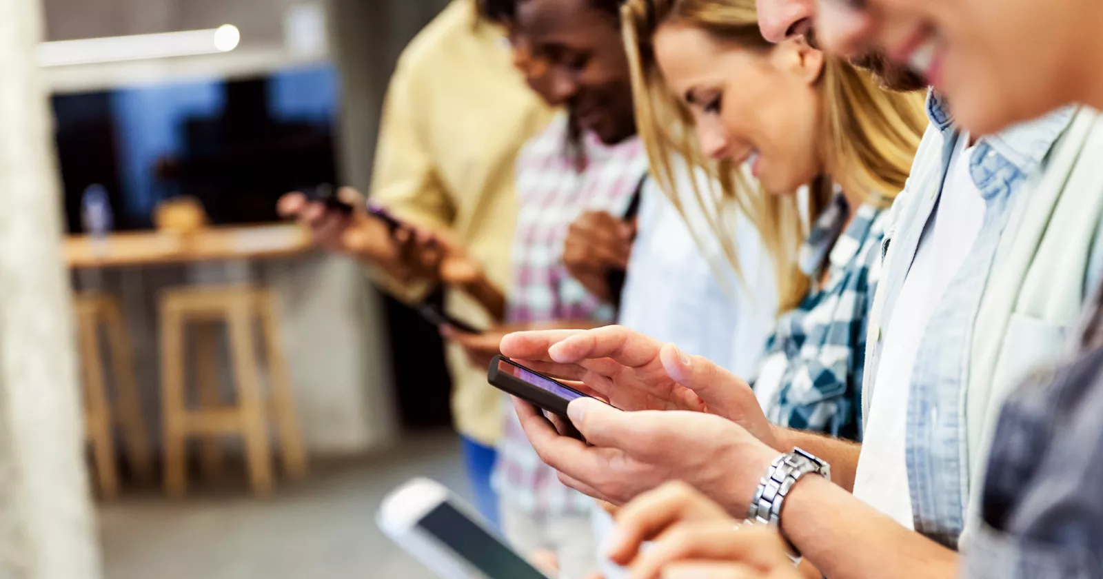 A group of young adults on phones. Exponent provides scientific and engineering expertise for consumer electronics and products.