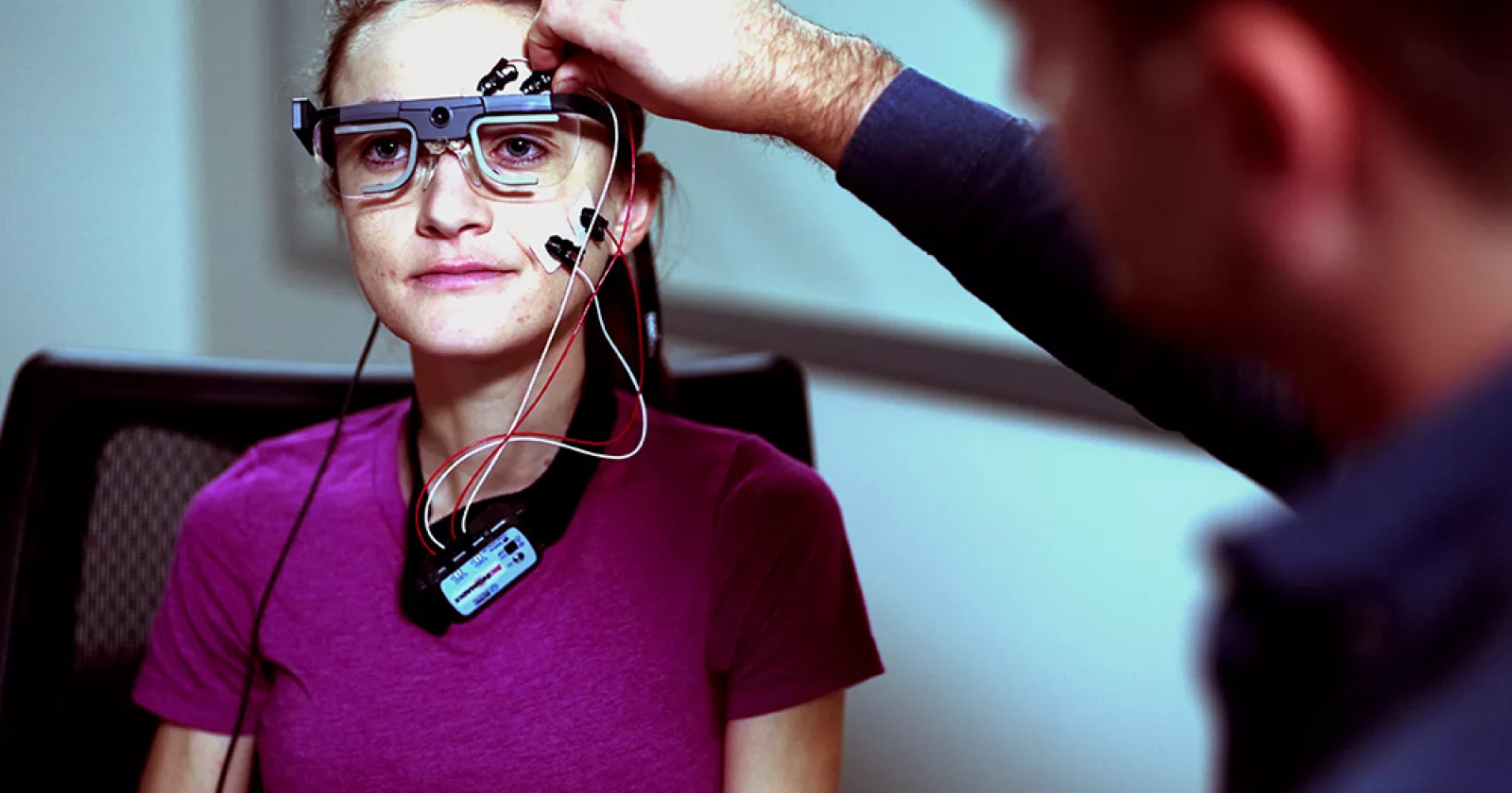 Exponent scientists attach bio sensors to a young person in a user experience lab to monitor movement. 