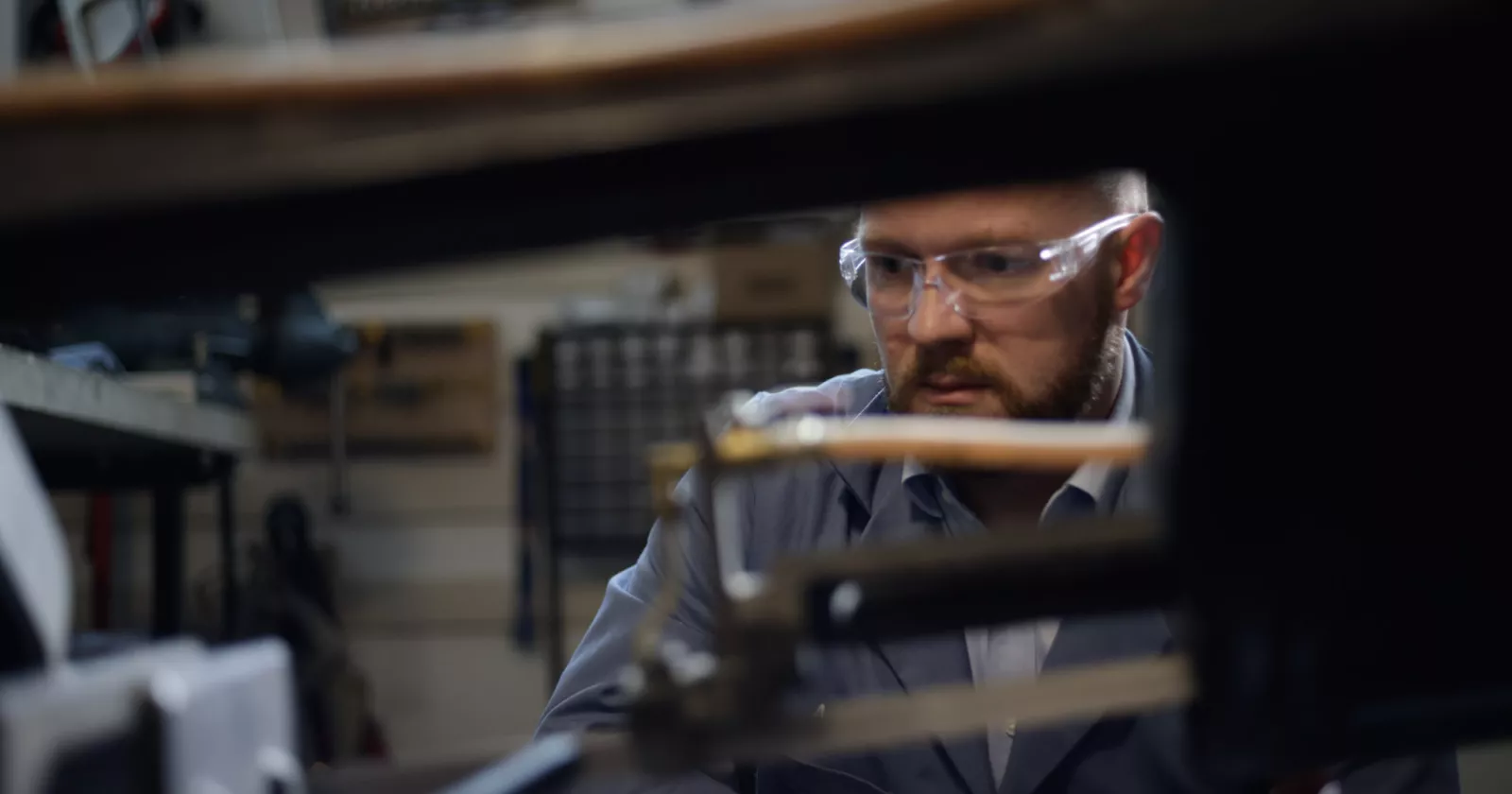 A worker examines mechanical components in Exponent's Natick research laboratory. 